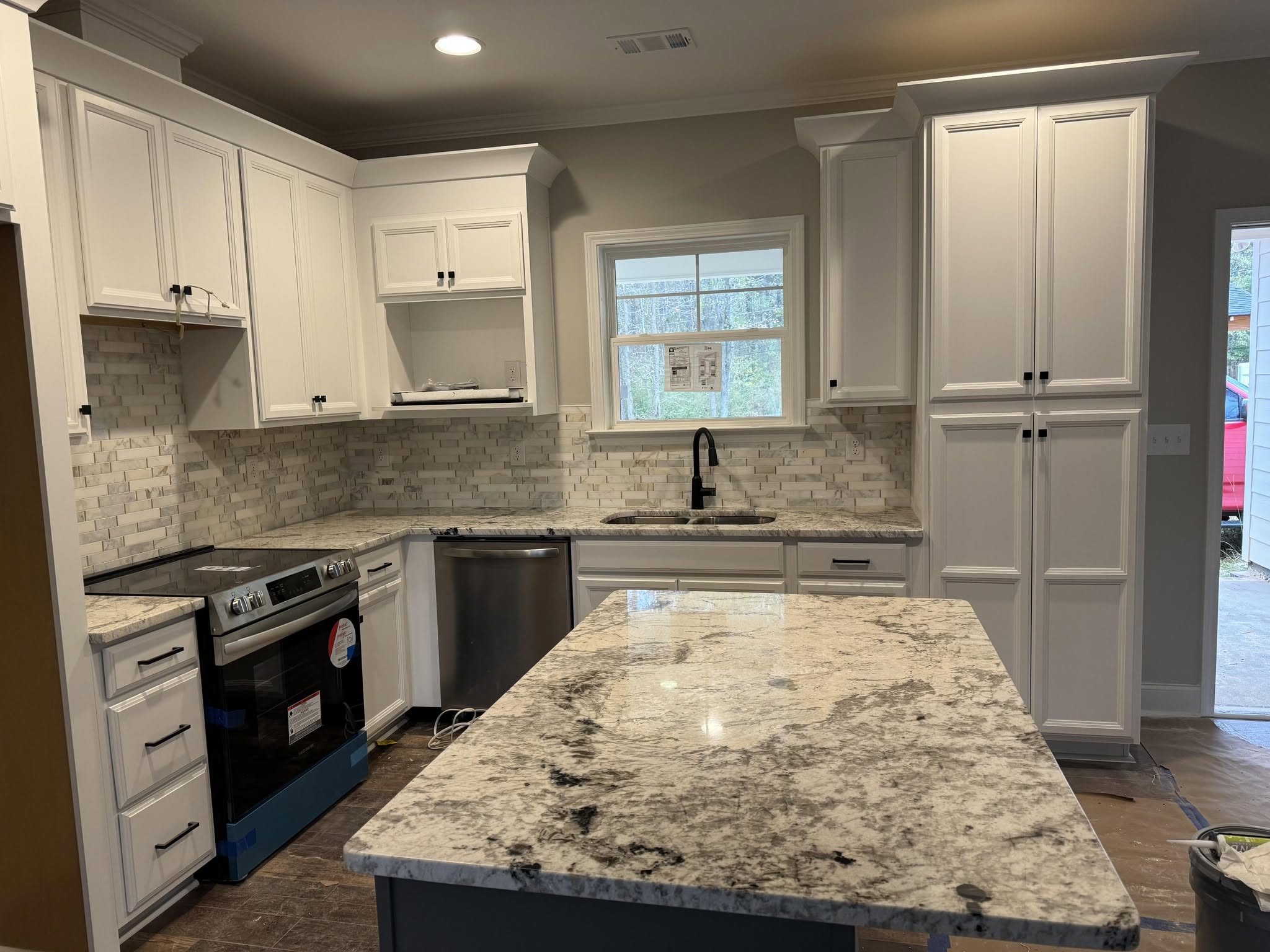White kitchen with granite island and custom cabinets