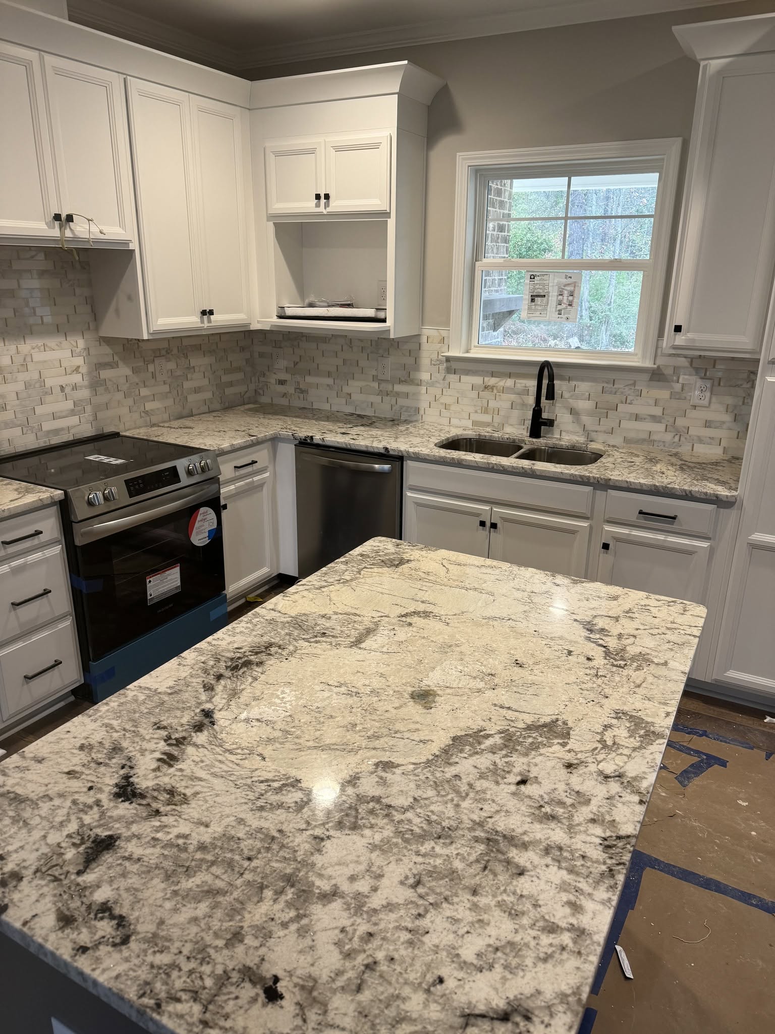 Granite countertops with white cabinets and black fixtures