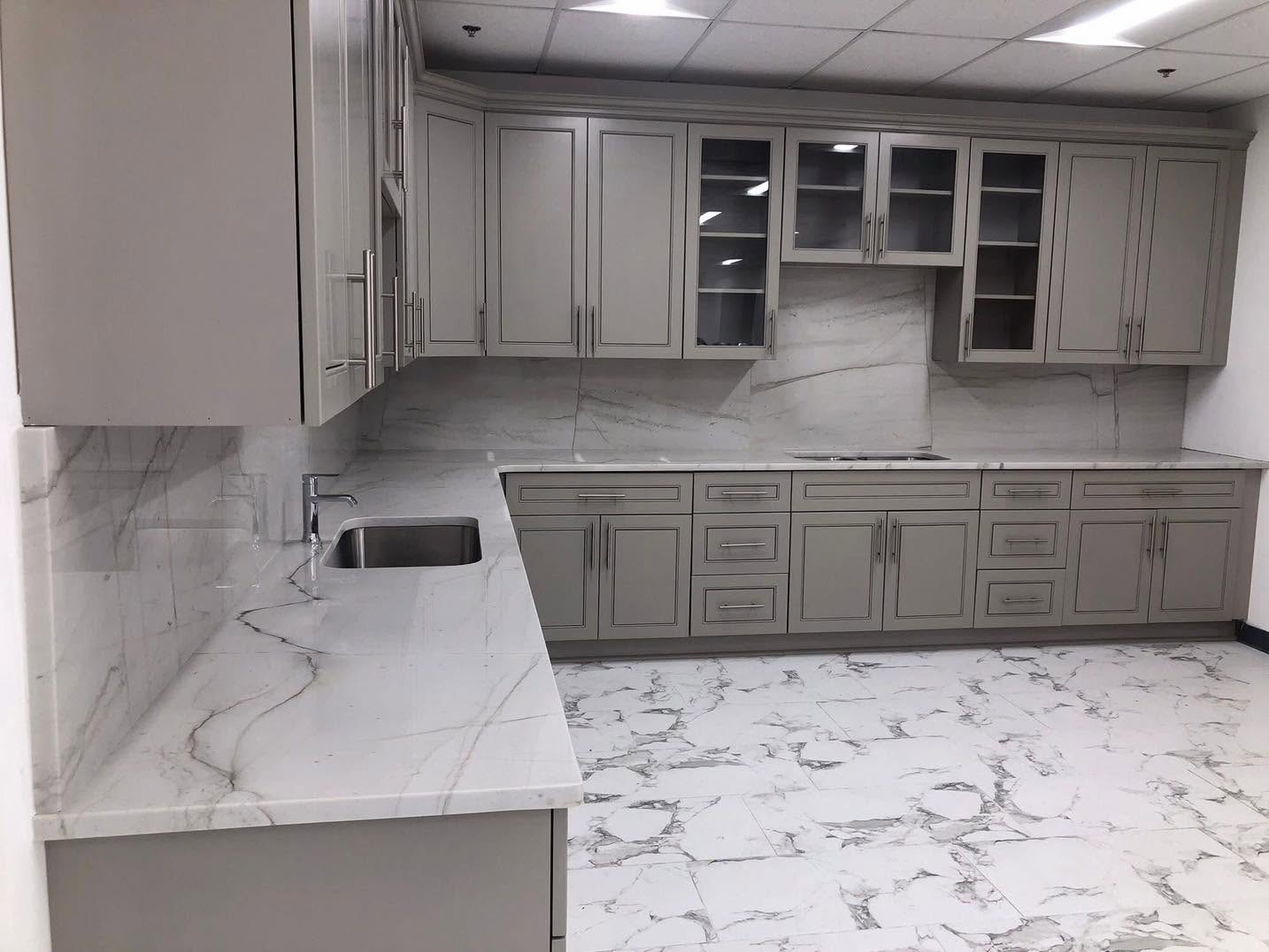 Gray custom cabinets with marble-look countertops and backsplash