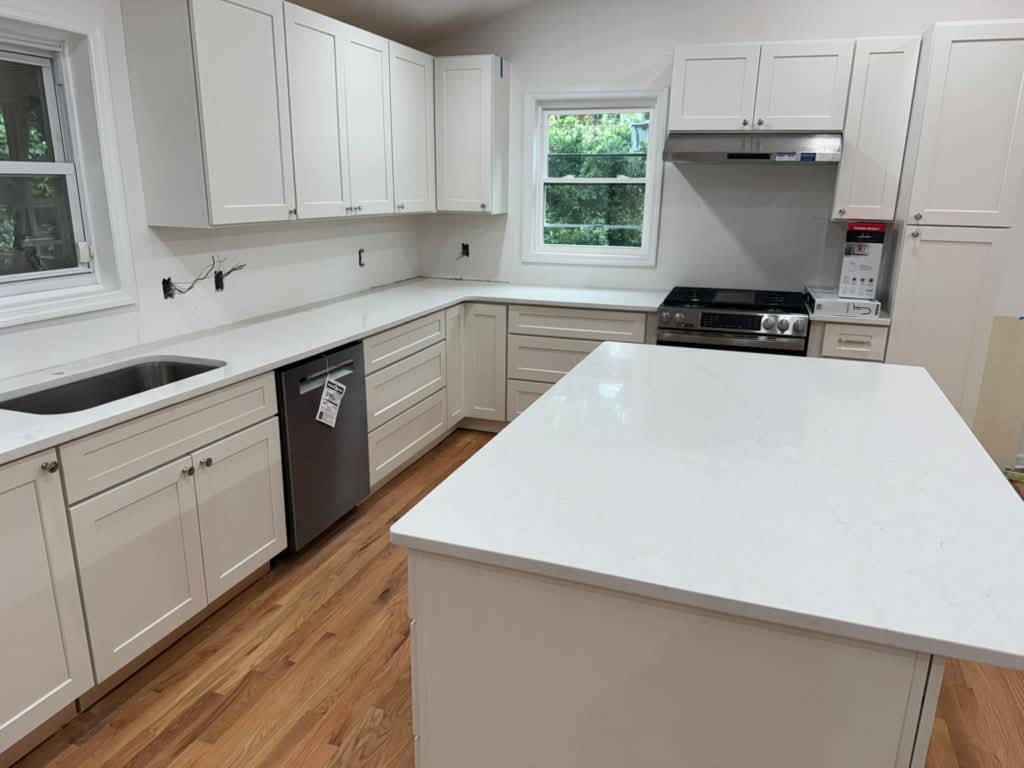 Remodeled white kitchen with island and stone countertops