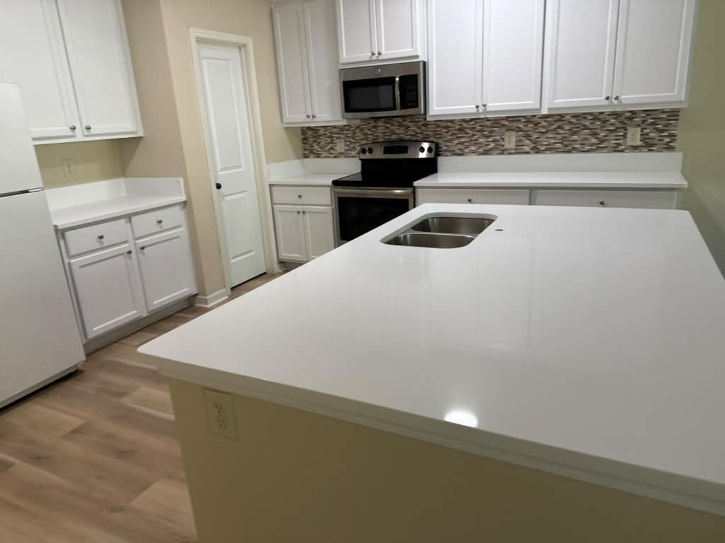 White kitchen island with double sink and mosaic backsplash