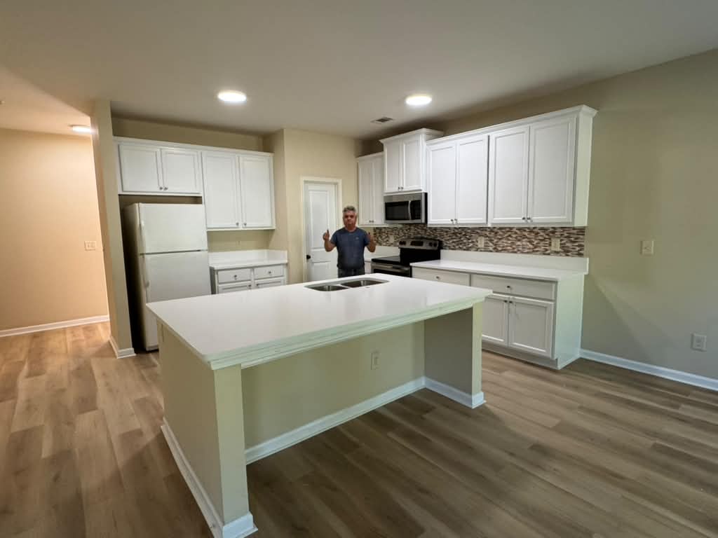 White kitchen with island, double sink, and custom cabinets